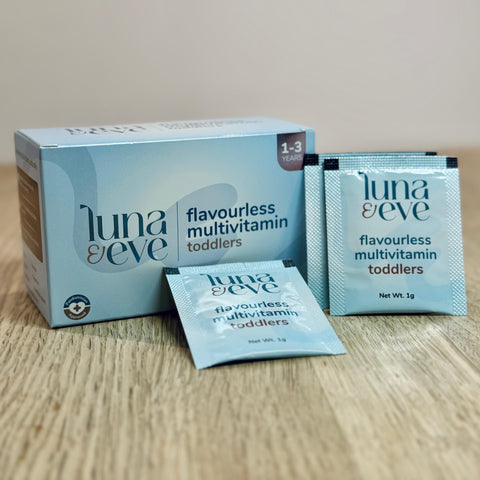 Luna & Eve flavourless multivitamin for toddlers packaging and individual sachets on a wooden surface 